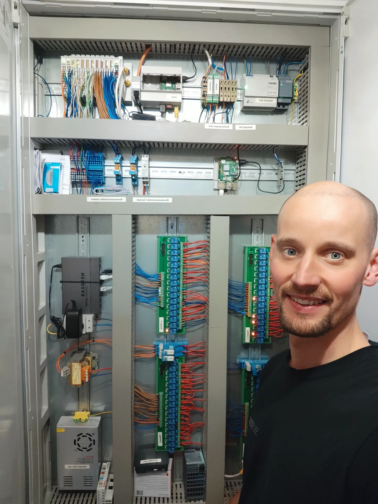 Christian Pütter vor einem Automatisierungs-Schaltschrank mit SPS-Steuerung